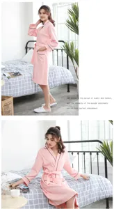 Comfortable pink cotton bathrobe for women, featuring black piping, long sleeves and belt.