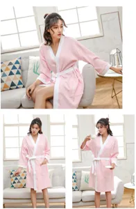 Detailed view of women waffle cotton bathrobe in pink and white, comfortable home loungewear.