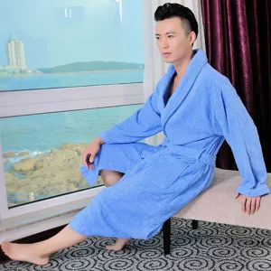 Detail shot of a comfortable blue cotton bathrobe worn by a male model near the sea window.