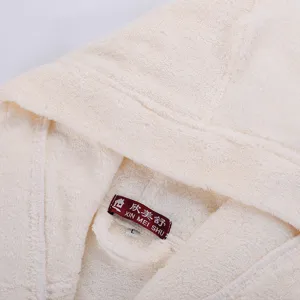 Detailed shot of pure cotton thick terry cloth bathrobe collar with hood and brand label.