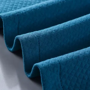 Teal cotton quilted bathrobe fabric close-up, soft and warm texture for comfortable sleepwear.