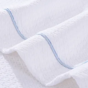 White waffle knit bathrobe main view, soft cotton hotel sleepwear with blue trim.