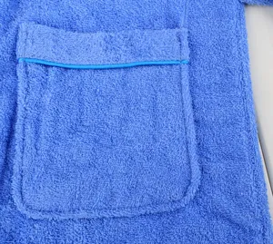 Blue cotton terry cloth bathrobe pocket detail close-up showing soft fabric and neat blue piping.