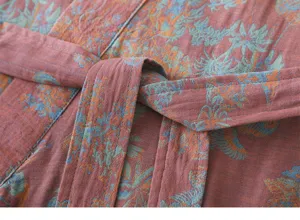 Detailed view of the soft cotton bathrobe fabric texture, showing belt and botanical print.