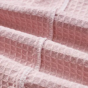 Pink waffle weave hotel bathrobe fabric close up texture detail soft comfortable wear