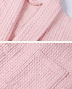 Detailed view of the pink cotton waffle bathrobe, showing soft fabric texture and collar.