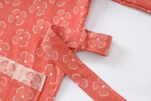 Close-up detail of double gauze cotton loungewear featuring a clover pattern in coral.