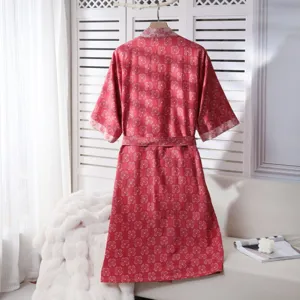 Detail shot of red cotton bathrobe with floral print hanging on screen, home wear style.