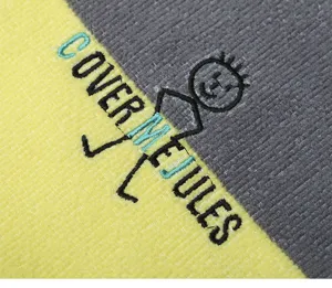 Microfiber hooded beach towel poncho detail, quick dry absorbent bathrobe fabric texture.