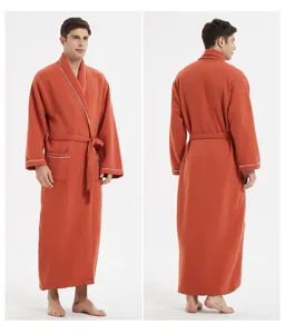 Detail view of the men's long waffle knit bathrobe in orange with white trim, belt, and pockets.