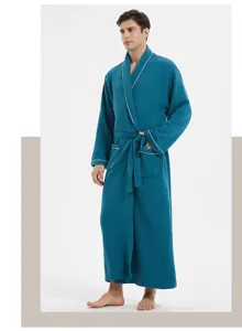 Detailed view of a long waffle weave men bathrobe in teal with contrast white piping and belt.