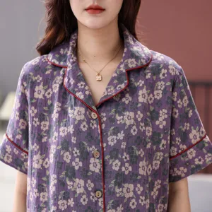Close up of pure cotton double layer gauze short sleeve pajama top with floral print and red piping.