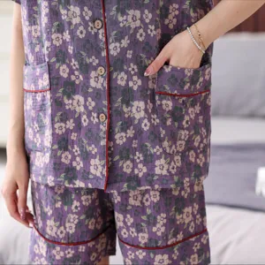Close-up detail of purple floral double gauze short sleeve pajama set with red piping.