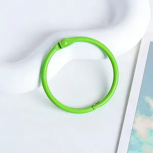 Gros plan d'un anneau de reliure en métal vert vif, idéal pour le bricolage DIY et papeterie.