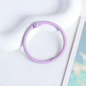 Détail d'anneau de livre en métal violet, parfait pour les loisirs créatifs et classeurs.