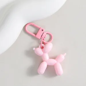 Close-up detail of the cute pink balloon dog keychain pendant, featuring glossy finish.