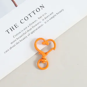 Close up of orange heart shaped metal spring snap clasp, diy jewelry accessory detail shot.