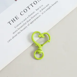 Close-up of a vibrant green heart-shaped lobster clasp snap hook for DIY jewelry crafts.