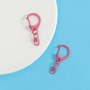 Detail view of pink metal keychain D-ring clasp, candy color zinc alloy DIY craft hardware.