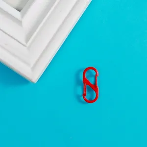 Gros plan sur un mousqueton porte-clés rouge en S, idéal pour les accessoires et pendentifs.