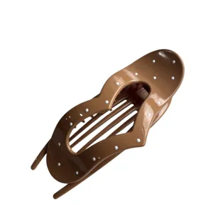 Brown glossy polka dot heart hair claw clip, stylish detail close up view for daily chic hair styling.