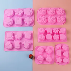 Detail view of various pink silicone molds with cute shapes for baking and dessert making.