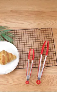 Stainless steel food tongs with red silicone grip and tips for safe kitchen baking use.