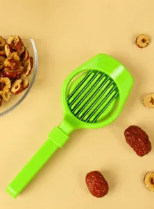 Green plastic red date pitter and slicer kitchen tool with stainless steel blades for fruit.