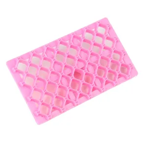 Vue de détail du moule à biscuits en plastique rose avec texture grille losange fondant.