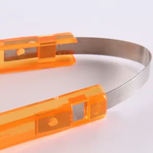 orange plastic handle stainless steel food tong detail view close up kitchen accessory