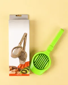 Green plastic fruit slicer and egg cutter tool detail view with product packaging box.