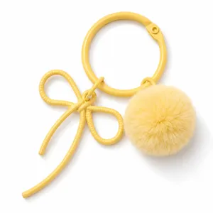 Yellow bow keychain with fluffy pom-pom charm detail shot, cute DIY bag charm pendant.