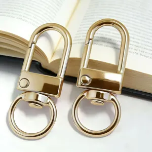 Closeup of gold metal U-shaped keychain snap hooks, durable diy hardware accessory.