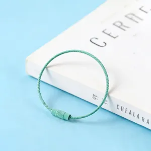 Gros plan détaillé de la boucle de porte-clés en fil d'acier enduit vert clair, accessorie DIY.