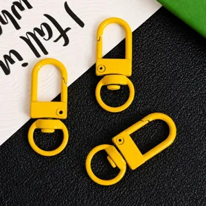 Detail view of yellow zinc alloy swivel snap hooks, keychain hardware and DIY bag accessories.