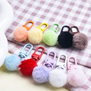 Colorful faux fur pom pom keychain detail view, fluffy plush ball bag charm pendant accessory.