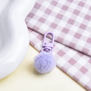 Cute plush pom pom keychain with light purple fluffy ball and metal lobster clasp accessory.