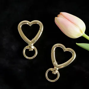 Detailed close-up view of gold heart-shaped spring clips, ideal for DIY bag accessories.