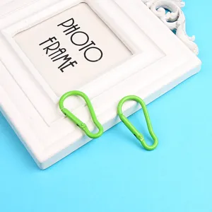 Primo piano di un moschettone portachiavi in alluminio verde brillante per accessori fai da te.