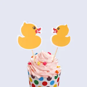 Close-up detail of cute yellow duck cake toppers inserted in sweet pink cream cupcake.