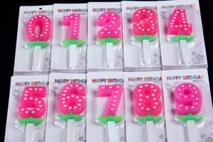Detailed view of pink number 0-9 birthday candles set with white hearts for party cake baking.