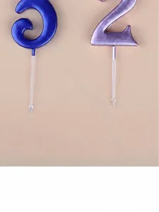 Detail view of colorful digital number candles with clear plastic sticks for party decor.