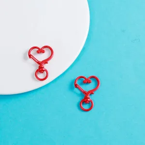 Gros plan de mousquetons rouges en forme de cœur en alliage pour bijoux DIY et loisirs créatifs.