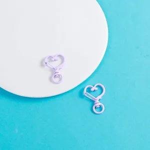 Détail en gros plan de fermoir mousqueton cœur violet, accessoires bijoux DIY en alliage.