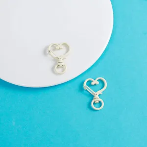 Vue rapprochée de fermoirs mousquetons cœur, idéaux pour la fabrication de bijoux DIY et pendentifs.