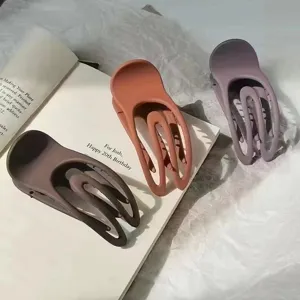 Minimalist matte hair claw clip with unique concave hollow design, perfect for stylish updos.
