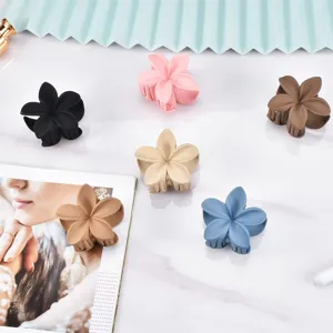 Matte plumeria flower hair claw clip for women, colorful aesthetic styling hair accessory.