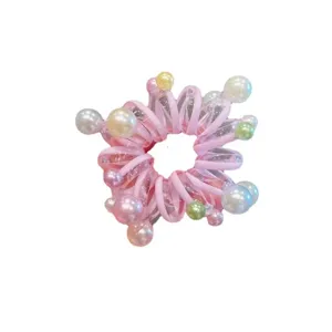 Primo piano dettagliato di un elastico per capelli rosa trasparente con perle colorate.