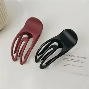Matte concave hair claw clip for women, simple aesthetic hair styling accessory detail view.
