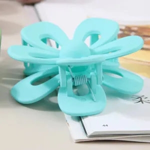 Close-up detail of the matte blue hollow flower hair claw clip for women's hairstyle